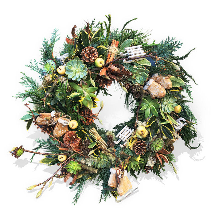 Christmas wreath with playful motifs, apples, succulent plants and pinecones