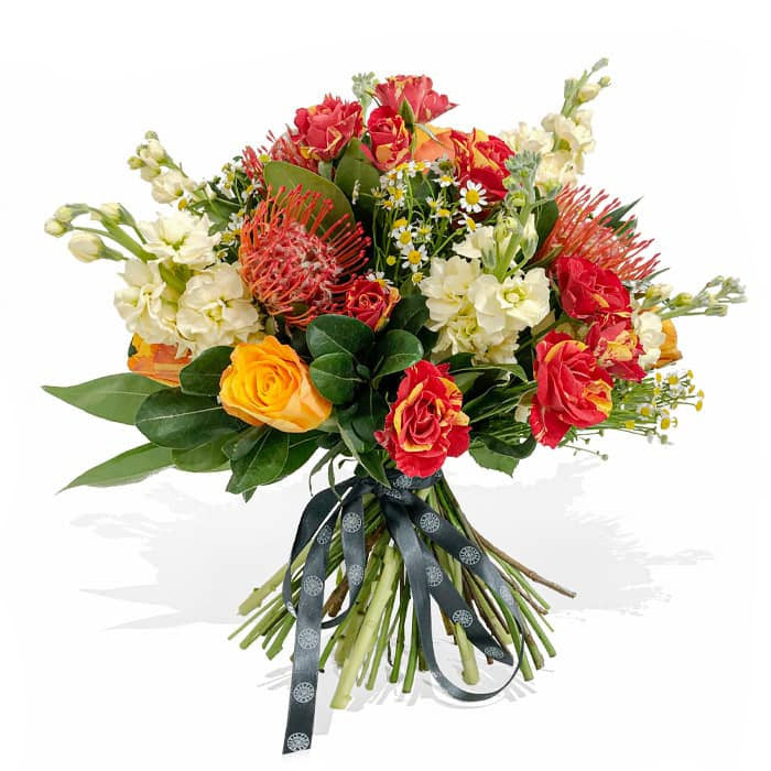 An outstanding selection of ecuadorian roses, proteas, spray roses and white stocks beautifully wrapped in a bouquet that will not leave you indifferent. Chamomile flowers and lush foliage will complete this arrangement that surely will remain as one of your favourites.