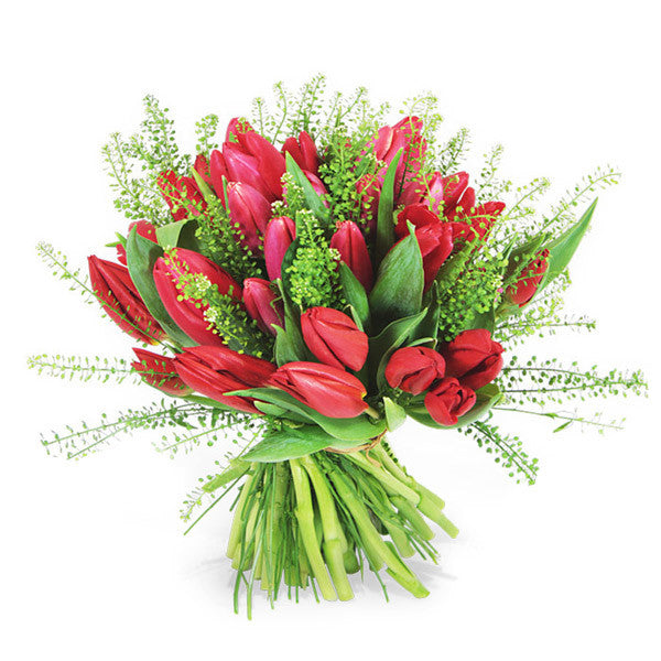 A bunch of red tulips arranged elegantly with lush Italian foliage